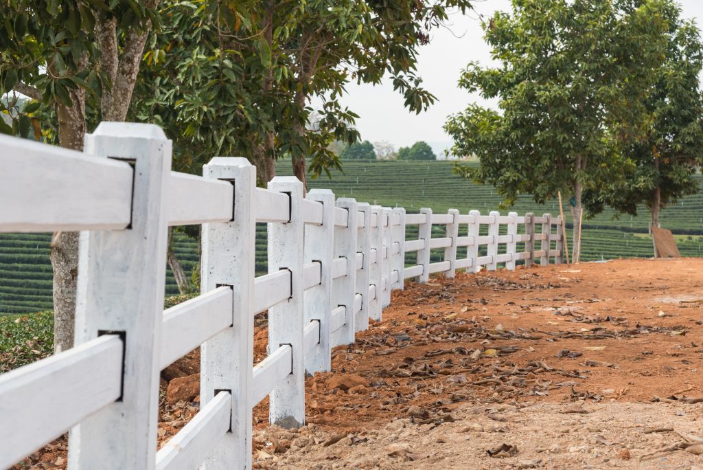 white fence installed on ground in tea plantation